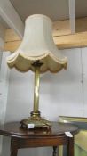 A brass Corinthian column table lamp with shade.