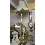 A brass standard lamp with shade.