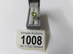 An oval cut three stone diamond and peridot ring ina 9ct gold shank. size P.