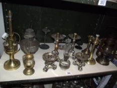 A selection of metal candlesticks, oil lamps etc.