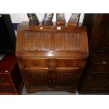 An oak bureau with carved drop front.