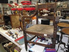 A 17th century style oak open armchair, rectangular cresting rail carved with a central flower head.