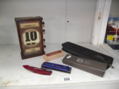 A wooden turning perpetual calendar, a harmonica, Kershaw blade trader etc.