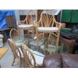 A large glass topped conservatory table with 8 cane chairs