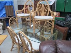 A large glass topped conservatory table with 8 cane chairs