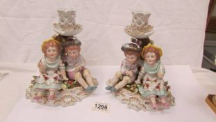 A pair of boy/girl figural group candlesticks.