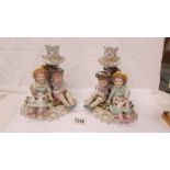 A pair of boy/girl figural group candlesticks.