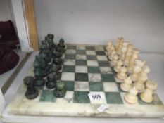 A polished stone chess set, some pieces a/f.