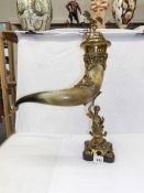 A fabulous table centrepiece of a large cow horn supported by a brass figure and with brass