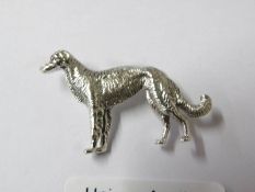 A silver dog brooch.