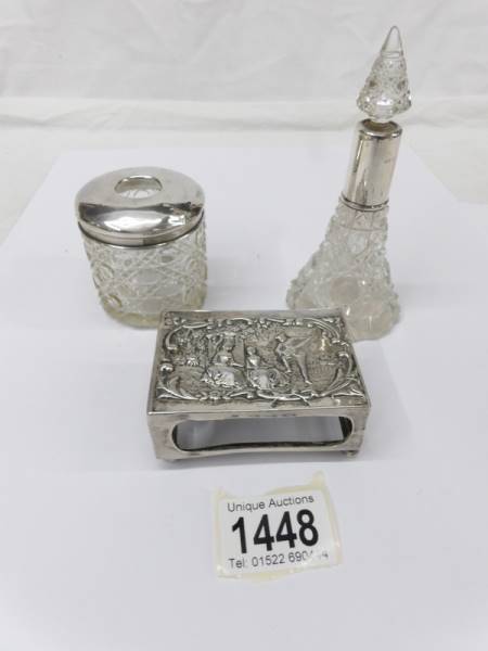 A silver topped hair pot, a scent bottle and a matchbox holder.