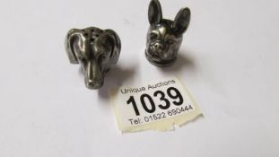 2 silver pepper pot tops in the form of a pug and a dachsund heads, 17.3 grams.