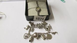 A silver marcasite ladies wristwatch and an old charm bracelet with 15 mainly silver charms.