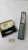 A cased gold/silver? stick pin featuring a stirrup and a cased art deco style wrist watch.
