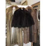 2 fur coats and a fur cape.