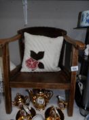 A vintage child's chair with cushion.