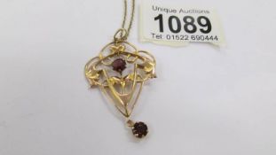 A lovely 9ct gold art nouveau pendant (4.3 grams with stones) on an unmarked yellow metal chain.