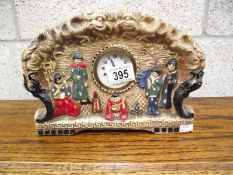 A plaster mantel clock featuring an oriental scene, marked too rear 'Emboss ware'.