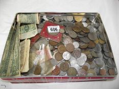 A box of coins and a large tin of foreign, UK coins and bank notes.