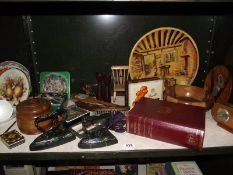 A mixed shelf of wooden items, collectable tins, large plaster plaque etc.