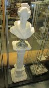 A female bust with marble base on Corinthian style stand.