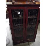 A dark wood stained display cabinet with leaded glass doors.