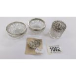 A pair of glass salts with silver rims, a cut glass pot with silver lid and a silver ARP badge.
