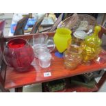 A shelf of various coloured glass etc