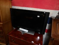 A Phillips 32" television with remote control.