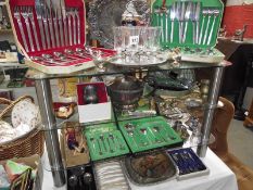 4 shelves of plated flatware, cutlery and other metalware including teapot.