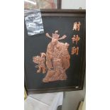 A framed ornate overlaid copper oriental Holy Man with child attendant, 54 x 67 cm.
