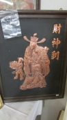 A framed ornate overlaid copper oriental Holy Man with child attendant, 54 x 67 cm.