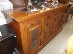 A late 19th century oak sideboard with carved art nouveau panels.