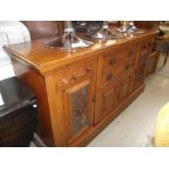 A late 19th century oak sideboard with carved art nouveau panels.