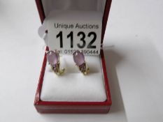 A pair of 10ct yellow gold amethyst and diamond earrings.