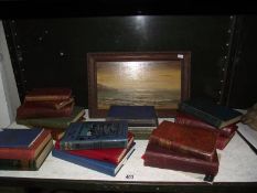 A selection of old books and a signed oil on board of a beach scene.