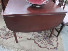 A drop leaf mahogany effect dining table