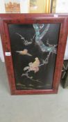 An oriental framed panel with abalone overlaid birds and foliage, 59 x 34 cm.