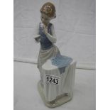 A Lladro figure of a lady ironing.