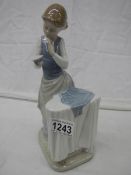 A Lladro figure of a lady ironing.