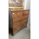 An oak 2 over 3 chest of drawers with brass handles.