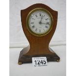 A small Maple & Co., inlaid mantel clock on brass ball feet, in working order.