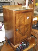 A figured walnut shelved cabinet with glass top.