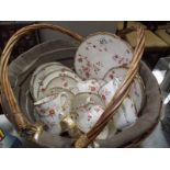 A floral porcelain tea set in basket.