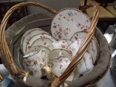 A floral porcelain tea set in basket.