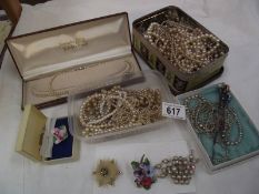 A quantity of faux pearl necklaces, several hat pins and vintage brooches.