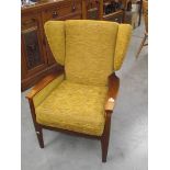 A retro 1970's teak framed wing arm chair. (collect only).