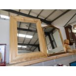A large gilt framed mirror and a large wood framed mirror.