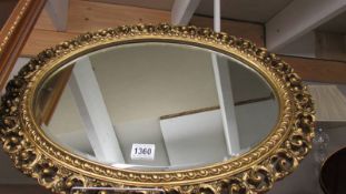 A oval gilt framed mirror, 49 x 33 cm.