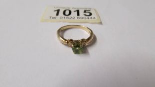 A peridot gem stone ring with diamond shoulders in 9ct gold, size N,